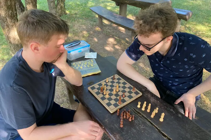 Two young men playing chess outdoors