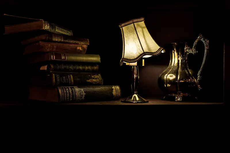 An old desk lamp beside a stack of books